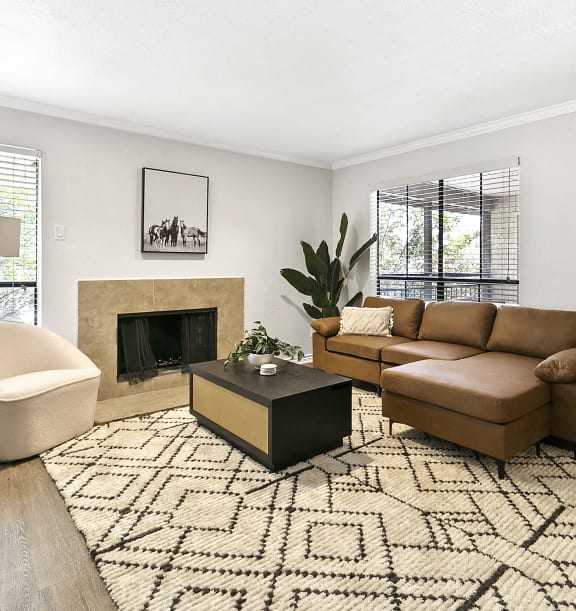 a living room with a couch and a coffee table and a fireplace at Lakeside Apartments, Texas, 75231