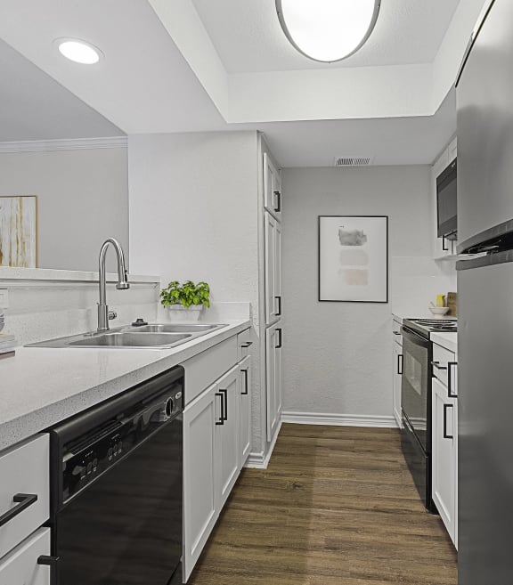 a large kitchen with stainless steel appliances and white counters at Lakeside Apartments, Texas, 75231